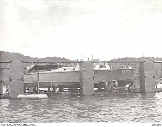 RABAUL, NEW BRITAIN, 1945-12-13. AN AUSTRALIAN MADE FLOATING DOCK IN SIMPSON HARBOUR WITH A ROYAL NEW ZEALAND AIR FORCE CRASH BOAT IN THE SLIPS