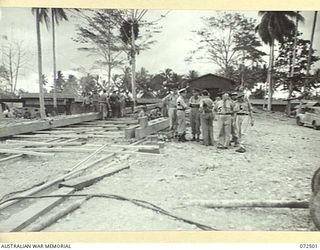 MILNE BAY, NEW GUINEA. 1944-04-21. THE HONOURABLE E.J. WARD, MINISTER FOR EXTERNAL TERRITORIES IN THE AUSTRALIAN GOVERNMENT (4), WITH THE OFFICIAL PARTY INSPECTING THE ROYAL AUSTRALIAN NAVY SLIPWAY ..