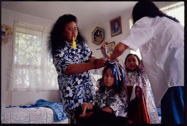 Kayne Lucas Upokokeu's hair is tied into seperate locks by his aunt and grandmother before a hair-cutting ceremony