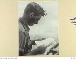 AITAPE AREA, NEW GUINEA. 1945-02-13. VX22598 LIEUTENANT P C BEENIE, READING HIS MAIL ON HIS RETURN TO CAMP WITH "JOCK FORCE". "JOCK FORCE" WAS A PATROL OF TWO OFFICERS AND TEN MEN OF THE 2/2ND ..