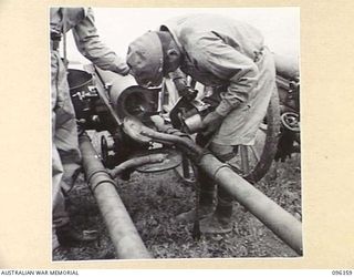 KAIRIRU ISLAND, NEW GUINEA, 1945-09-08. A JAPANESE SOLDIER REMOVING THE BREECH BLOCK FROM A 75 MM MOUNTAIN GUN. STAFF OFFICERS OF HQ 6 DIVISION VISITED THE ISLAND TO MAKE ARRANGEMENTS WITH JAPANESE ..