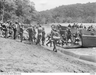 LANGEMAK BAY, NEW GUINEA, 1943-10-28. MEMBERS OF THE 2/24TH AUSTRALIAN INFANTRY BATTALION BOARDING BARGES AT THE BEACHHEAD