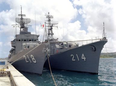 Starboard bow view of the Japanese frigates JDS TOKACHI (DE 218), left, and JDS OOI (DE 214) moored in Apra Harbor