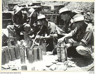 DALLMAN RIVER, NEW GUINEA, 1944-02-23. MEMBERS OF THE 2/14TH FIELD REGIMENT AT MAINTENANCE WORK ON 25 POUNDER AMMUNITION. IDENTIFIED PERSONNEL ARE: VX35161 GUNNER A.H. ALLEN (1); VX44246 GUNNER ..