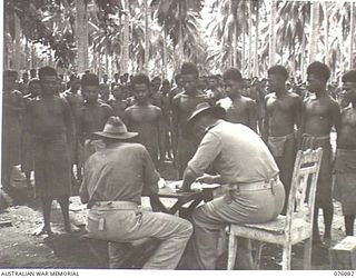 KARKAR ISLAND, NEW GUINEA. 1944-09-18. PERSONNEL OF THE AUSTRALIAN NEW GUINEA ADMINISTRATIVE UNIT RECRUITING BOYS FROM VILLAGES FOR WORK ON THE PLANTATIONS