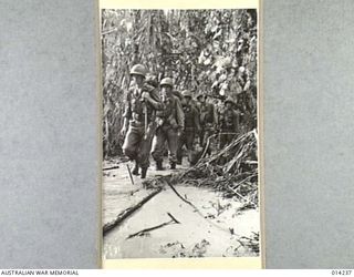 1943-01-27. PAPUA. ALLIED ADVANCE ON SANANANDA. WATER, MUD, AND SLUSH ARE ALMOST THE ALLIED TROOPS INSEPARABLE COMPANIONS IN PAPUA. AMERICAN TROOPS ON THEIR WAY TO JOIN THE AUSTRALIANS NEAR ..