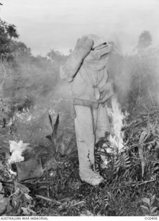 KIRIWINA, TROBRIAND ISLANDS, PAPUA. 1943-11-12. LEADING AIRCRAFTMAN R. P. CONWAY OF KENSINGTON, NSW, WEARS A PROTECTIVE SUIT FOR FIGHTING FIRES AT CLOSE QUARTERS