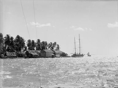 [Yacht and a boat in front of Pacific Island buildings]