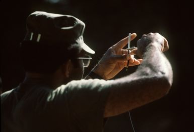 MSGT Moore, a member of the combat control team (CCT), prepares a detonation cord for an explosives charge. He is being trained in the demolition of explosives