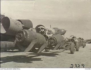 TADJI AIRSTRIP, AITAPE, NORTH EAST NEW GUINEA. 1945-03-30. THIS BOMB LOAD ON THE TROLLEYS IS FOR THE JAPANESE IN THE TORRICELLI MOUNTAINS OF NEW GUINEA AND IS TO BE DELIVERED BY BEAUFORT BOMBER ..