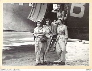 LAE AIRSTRIP, NEW GUINEA. 1945-09-25. MEMBERS OF THE DARYA COLLIN BALLET TROUPE ALONGSIDE THE RAAF AIRCRAFT WHICH BROUGHT THEM TO LAE. THE TROUPE HAS BEEN TOURING THE ISLANDS GIVING AN AVERAGE OF ..