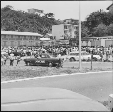 Spectators gathered in front of apartment blocks during the 1st Safari Calédonien racing event, New Caledonia, 1967 / Michael Terry