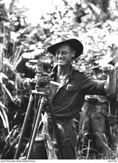 WEWAK AREA, NEW GUINEA, 1945-07-03. BRIGADIER M.A. SPOONER, 2/6 SURVEY BATTERY, ROYAL AUSTRALIAN ARTILLERY, USING A THEODOLITE TO READ ANGLES. EACH AUSTRALIAN DIVISION IS NOW PROVIDED WITH AN ..