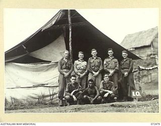 DUMPU, NEW GUINEA. 1944-04-19. STAFF OF THE INTELLIGENCE OFFICE, HEADQUARTERS 15TH INFANTRY BRIGADE OUTSIDE THEIR OFFICE TENT. IDENTIFIED PERSONNEL ARE:- VX140268 PRIVATE W.E. GREEN (1); SIGNOLI ..