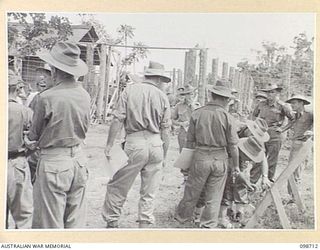 MISSION POINT, NEW GUINEA. 1945-11-09. SUSPECTED JAPANESE WAR CRIMINALS (AT THE LEFT) LINED UP FOR IDENTIFICATION. AUSTRALIAN SOLDIERS ASSISTING THE WAR CRIMES COMMISSION EXAMINE IDENTIFICATION ..