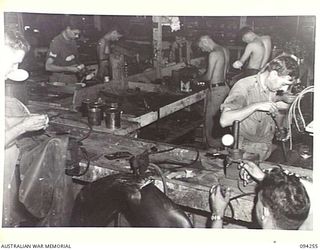 PALMALMAL PLANTATION, NEW BRITAIN. 1945-07-21. THE ELECTRICAL REPAIR SECTION AT 1 INFANTRY TROOPS WORKSHOP. THE MEN ARE WORKING ON AN ASSEMBLY LINE WHICH COMPLETELY OVERHAULS AND RECONDITIONS JEEP ..