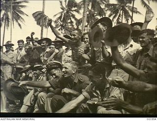 MADANG, NEW GUINEA. C. 1944-10. RAAF PERSONNEL LEND VOCAL SUPPORT CHEERING CONTESTANTS AT A SPORTS MEETING AT THE FORWARD BASE