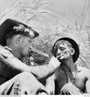 NEW GUINEA. GONA. THE AUSTRALIANS HAVE JUST COME 100 YARDS BACK FROM THE FRONT LINE FOR FOOD DURING A LULL IN THE FIGHTING. THEY ARE PART OF A COMPANY WHICH HAS BEEN 2 DAYS AND NIGHTS WITHIN ..