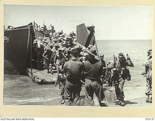 TSIMBA AREA, BOUGAINVILLE ISLAND. 1945-02-16. PERSONNEL OF NO. 12 FIELD BATTERY, 4TH FIELD REGIMENT LANDING FROM THEIR BARGES AT PUTO