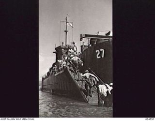 GILI GILI, NEW GUINEA, 1943-07-15. TROOPS OF THE 29TH AUSTRALIAN INFANTRY BRIGADE, 5TH AUSTRALIAN DIVISION, LOADING STORES BY "ROUND ROBIN" PRIOR TO EMBARKING ON AMERICAN LCI'S (LANDING CRAFT ..