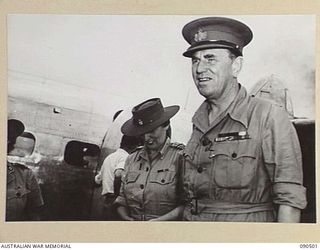 LAE, NEW GUINEA. 1945-03-26. LORD WAKEHURST, GOVERNOR OF NEW SOUTH WALES (2), ACCOMPANIED BY LADY WAKEHURST (1), ON ARRIVAL AT THE AIRSTRIP ON A 2-DAY VISIT TO HEADQUARTERS FIRST ARMY IN THE ..