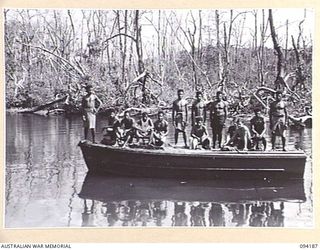 WEWAK AREA, NEW GUINEA. 1945-07-18. MEMBERS OF 2/22 FIELD PARK COMPANY, ROYAL AUSTRALIAN ENGINEERS, AND A PARTY OF AUSTRALIAN NEW GUINEA ADMINISTRATIVE UNIT NATIVES ARRIVING BY MOTOR LAUNCH AT ..