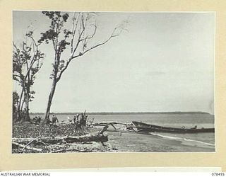 MOTUPINA POINT AREA, BOUGAINVILLE ISLAND. 1945-01-20. LOOKING ALONG THE BEACH FROM THE 2ND FIELD REGIMENT POSITION TOWARDS THE JAPANESE OCCUPIED MOTUPINA POINT. NOTE THE SUNKEN ENEMY BARGE IN THE ..