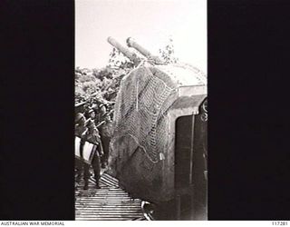 NAURU ISLAND. 1945-09-14. PERSONNEL OF THE 31/51ST INFANTRY BATTALION CHECKING THE DETAILS OF A JAPANESE TWIN BARREL 6" NAVAL GUN SOON AFTER THE OCCUPATION OF THE ISLAND
