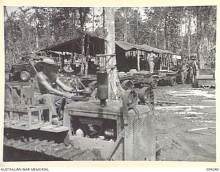 SOUTH BOUGAINVILLE. 1945-07-21. A TRACTOR TRAIN CONSISTING OF AN ARTILLERY TRACTOR AND JEEP TRAILERS PULLED IN AT A DETAIL ISSUING DEPOT AT HEADQUARTERS 3 SUPPLY DEPOT COMPANY, TO LOAD RATIONS FOR ..