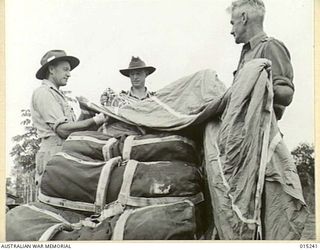 Wau-Mubo Area. Special parachutes dropped from transport aircraft along the Mubo track are re packed by possibly Private Otto Edwin Scholz of Wagga Wagga, NSW; VX10813 Captain William Kither ..