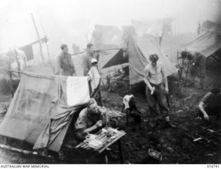 Finisterre Range, New Guinea. 27 March 1944. Surrounded by fog, high in the Finisterre Range, an Australian patrol has breakfast