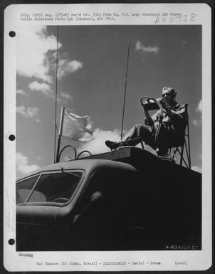 Metal Stick Operator T/Sgt. L.D. Arris Of 1017 W. 3Rd St., Los Angeles, Calif., Guides A Radio Controlled Plane From His Position On Top Of Radio Control Truck. Oahu, Hawaii, April 1945. (Wheeler Field). (U.S. Air Force Number A63410AC)