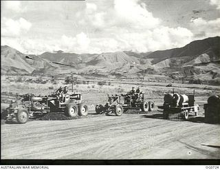 NADZAB, NEW GUINEA. C. 1944-02. GRADERS AND WATER CARTS OF NO. 62 MOBILE WORKS SQUADRON RAAF WORKING ON NEARLY COMPLETED AIRSTRIPS. THE MARKHAM VALLEY HILLS ARE IN THE BACKGROUND