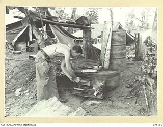 SEKULA, NEW GUINEA. 1944-07-30. SX27841 PRIVATE K.J. MANNIX, COOK, PREPARING LUNCH FOR MEMBERS OF THE 5TH DIVISION SALVAGE UNIT