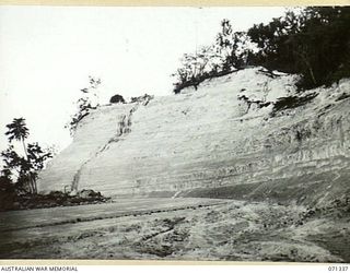 LANGEMAK BAY, NEW GUINEA, 1944-03-20. THIS CUT ON MARSH ROAD MADE BY C COMPANY, 870TH UNITED STATES AVIATION ENGINEER BATTALION MEASURING 80 FEET DEEP, 60 FEET WIDE AND 200 YARDS LONG ALLOWED THE ..