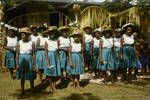 Schoolgirls wearing plaited palm frond hats decorated with flowers, East Coast, New Ireland, Jun 1964