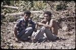 Land clearing: men take a break from cutting trees and bushes from rocky land, preparing for construction