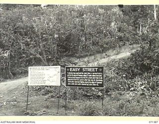 FINSCHHAFEN AREA, NEW GUINEA, 1944-03-20. TWO OF MANY BATTLE SIGNS IN THE FINSCHHAFEN AREA, THE SIGN TO THE LEFT RECORDS THE ACTIVITIES OF THE 2/13TH, 2/15TH, 2/17TH AND 2/43RD INFANTRY BATTALIONS, ..