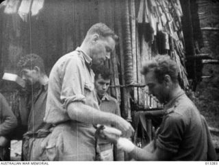 DR. W D STEWARD TENDING WOUNDED AT A FORWARD POST