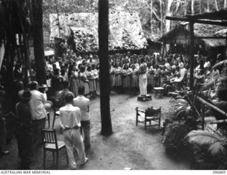 Ramale Valley, New Britain. A choir composed of the internees at Ramale Valley Internment Camp singing 'Minstrel Boy' for Major General K W Eather, General Officer Commanding 11 Division. Contact ..