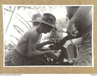 DONADABU AREA, NEW GUINEA. 1943-12-01. QX50876 GUNNER J. T. HUGHES OF NO. 4 GUN, NO. 7 BATTERY, 2/4TH AUSTRALIAN FIELD REGIMENT LOADING HIS GUN DURING THE COMBINED EXERCISE WITH THE 2/10TH ..