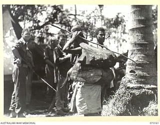 ALEXISHAFEN, NEW GUINEA. 1944-05-15. NEW GUINEA NATIVES WAITING TO BE FERRIED TO ADMOSIN ISLAND, THE TEMPORARY AUSTRALIAN NEW GUINEA ADMINISTRATIVE UNIT HEADQUARTERS, IN RESPONSE TO A CALL MADE TO ..