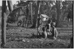 Woman and children sitting on grass next to houses