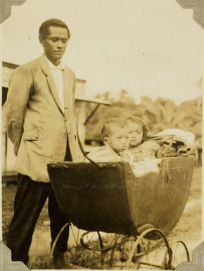 Tongan man with three children in one pram, 1928