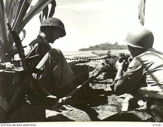 1943-07-31. ALLIED CAPTURE OF MUBO. A HEAVY AMERICAN MACHINE GUN FIRING ON LABABIA ISLAND DURING THE ALLIED ADVANCED FROM NASSAU BAY TO MUBO. THE CREW IS PTE. REX RIDDELL, OF BEND, OREGON, AND PTE. ..