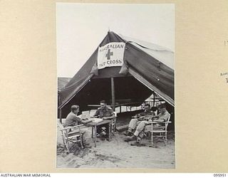 BORAM BEACH, WEWAK AREA, NEW GUINEA. 1945-08-31. PERSONNEL OF 2/15 FIELD AMBULANCE OUTSIDE THE RED CROSS SOCIETY REST CENTRE. IDENTIFIED PERSONNEL ARE:- LANCE CORPORAL W.L. WICKS (1); LIEUTENANT ..