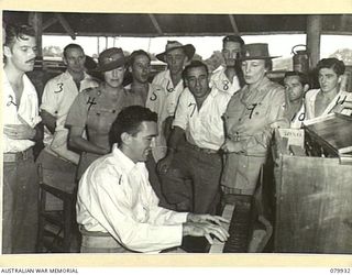 LAE, NEW GUINEA. 1945-03-27. LADY BLAMEY (4) WITH LADY WAKEHURST (9), WITH PATIENTS AT THE PIANO OF THE RED CROSS RECREATION HUT, 2/7TH GENERAL HOSPITAL, AUSTRALIAN ARMY MEDICAL CORPS