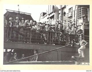 THE WHARF, JACQUINOT BAY, NEW BRITAIN, 1945-08-13. HEADQUARTERS 5 DIVISION TROOPS LINE THE DECK OF THE TROOPSHIP VAN OUTHOORN BEFORE SAILING FOR AUSTRALIA