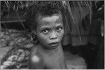 Mortuary ceremony, Omarakana: child with streak of mourning ash across face, wears turtle shell earrings