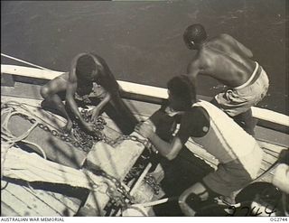 PORT MORESBY, PAPUA. C. 1944. PAPUAN NATIVES EMPLOYED AS CREW MEMBERS ON A SAILING VESSEL USED BY THE RAAF RESCUE SERVICE, AT WORK ON DECK